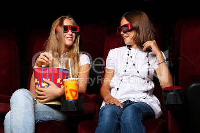 Two young girls watching in cinema