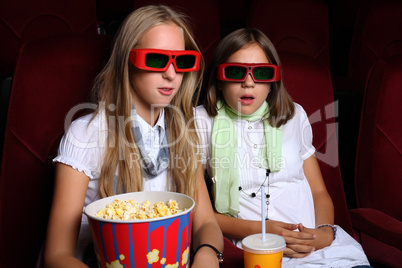 Two young girls watching in cinema