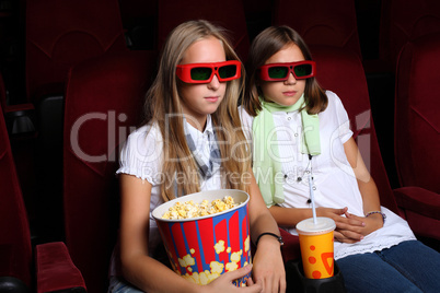 Two young girls watching in cinema