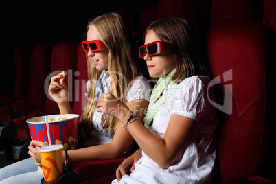 Two young girls watching in cinema