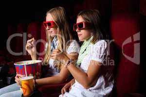 Two young girls watching in cinema