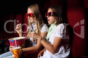 Two young girls watching in cinema