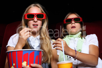 Two young girls watching in cinema