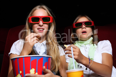 Two young girls watching in cinema