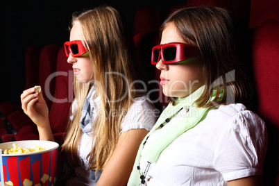 Two young girls watching in cinema