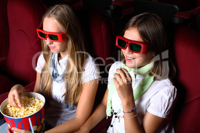 Two young girls watching in cinema