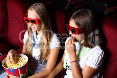 Two young girls watching in cinema