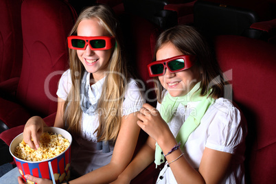 Two young girls watching in cinema