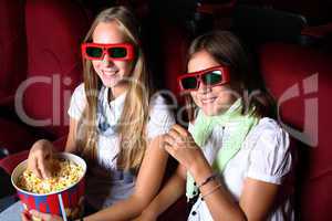 Two young girls watching in cinema