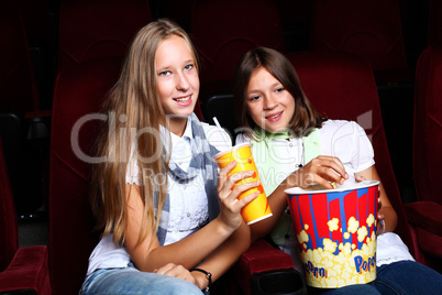 Two young girls watching in cinema