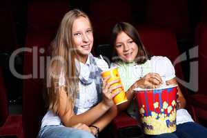 Two young girls watching in cinema