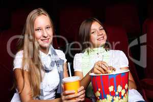 Two young girls watching in cinema