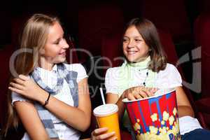 Two young girls watching in cinema