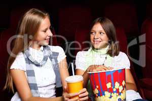 Two young girls watching in cinema