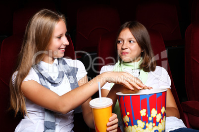 Two young girls watching in cinema