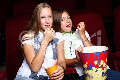 Two young girls watching in cinema