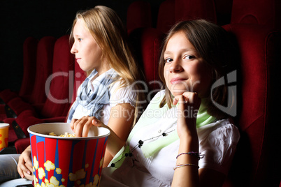 Two young girls watching in cinema