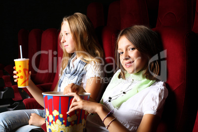 Two young girls watching in cinema