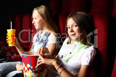 Two young girls watching in cinema