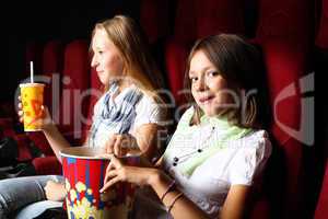 Two young girls watching in cinema