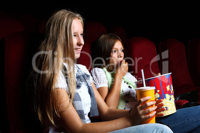 Two young girls watching in cinema