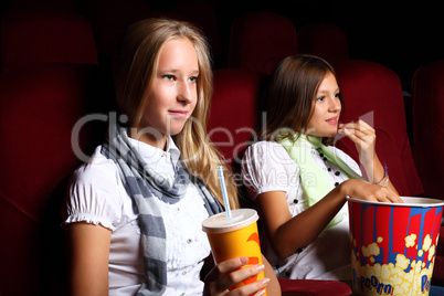 Two young girls watching in cinema