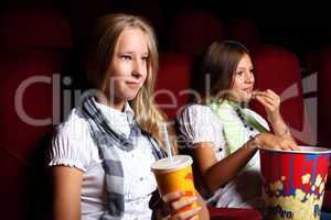 Two young girls watching in cinema