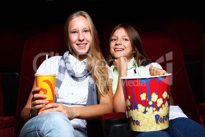 Two young girls watching in cinema