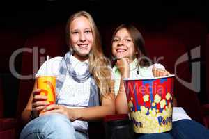 Two young girls watching in cinema