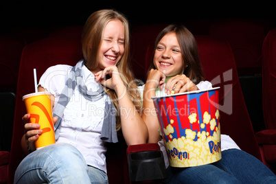 Two young girls watching in cinema