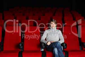 Young man in cinema watching movie