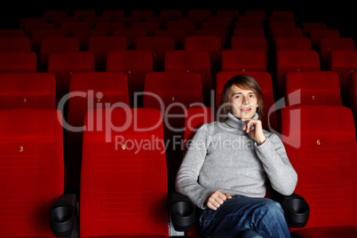 Young man in cinema watching movie