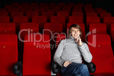 Young man in cinema watching movie