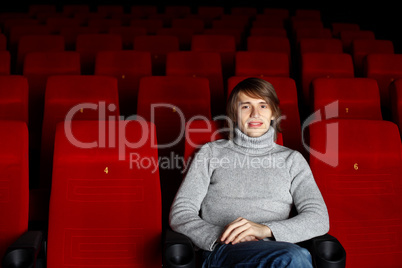 Young man in cinema watching movie