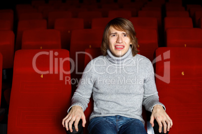 Young man in cinema watching movie