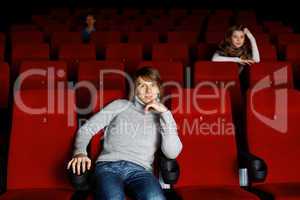 Young man in cinema watching movie