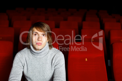 Young man in cinema watching movie