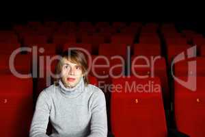 Young man in cinema watching movie