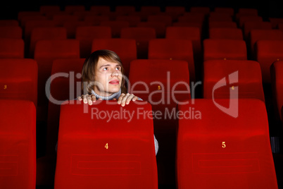 Young man in cinema watching movie