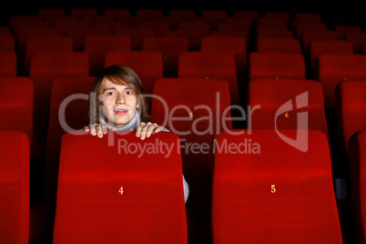 Young man in cinema watching movie