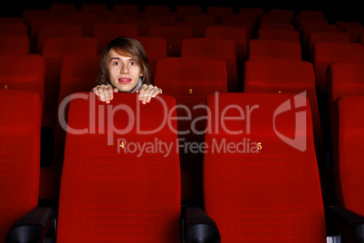 Young man in cinema watching movie