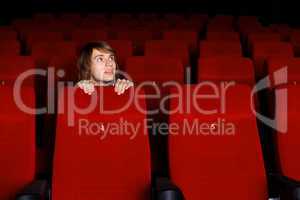 Young man in cinema watching movie