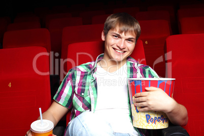 Young man in cinema watching movie