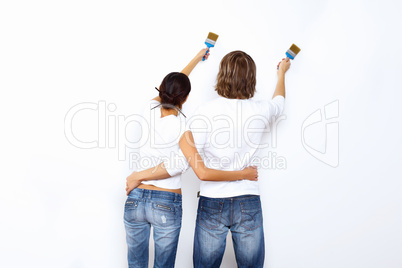 Young couple with paint brushes together