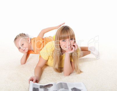 young mother reading a book to his daughter