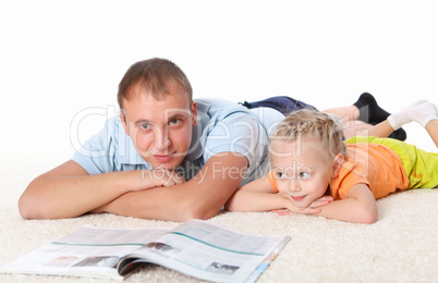 young father reading a book to his daughter