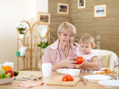 grandmother feeding granddaughter at home