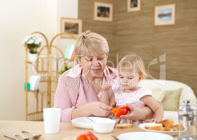 grandmother feeding granddaughter at home