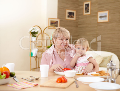 grandmother feeding granddaughter at home