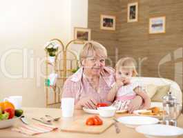 grandmother feeding granddaughter at home